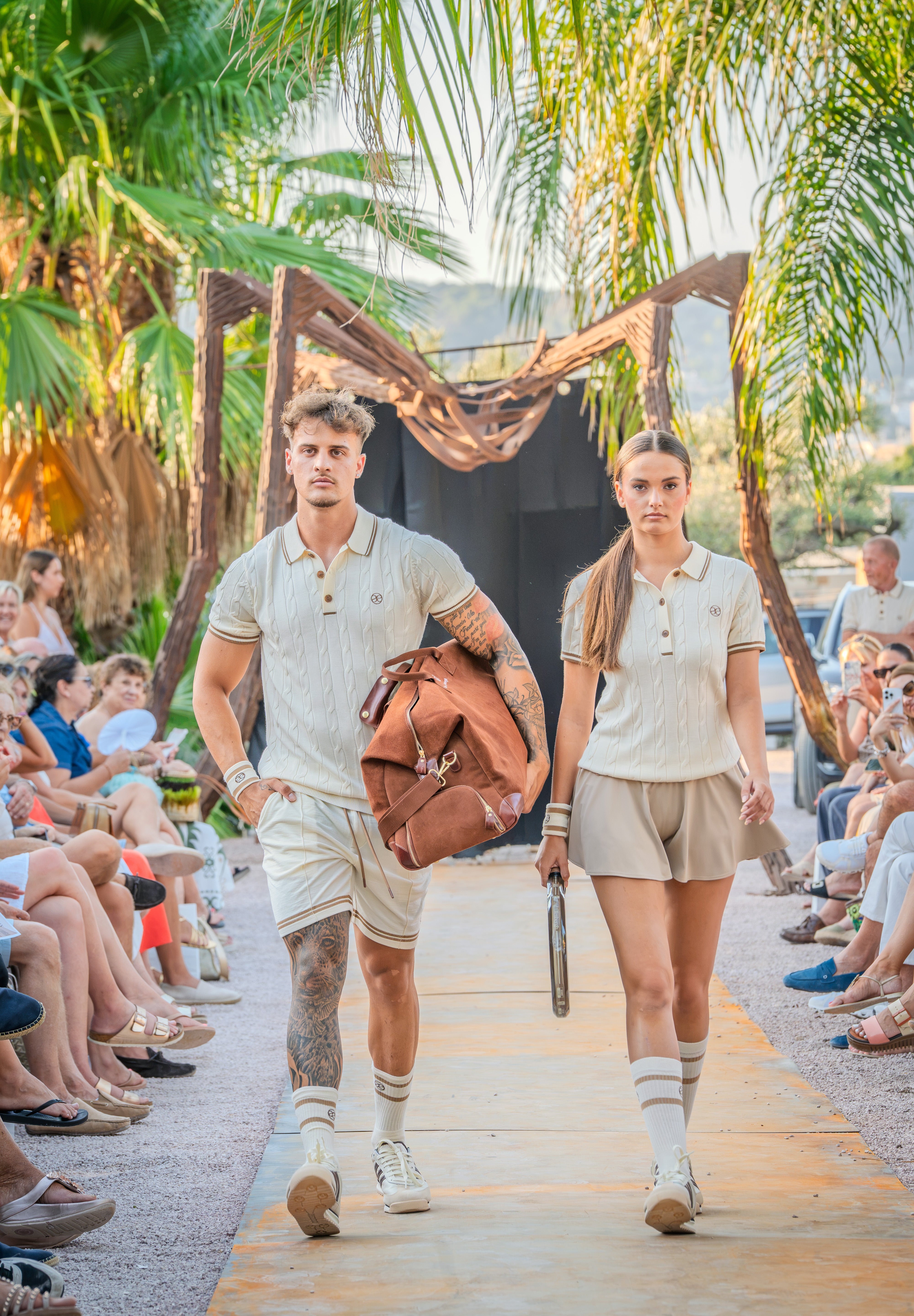 Two models walking the outdoor runway at La Fábrica fashion show.