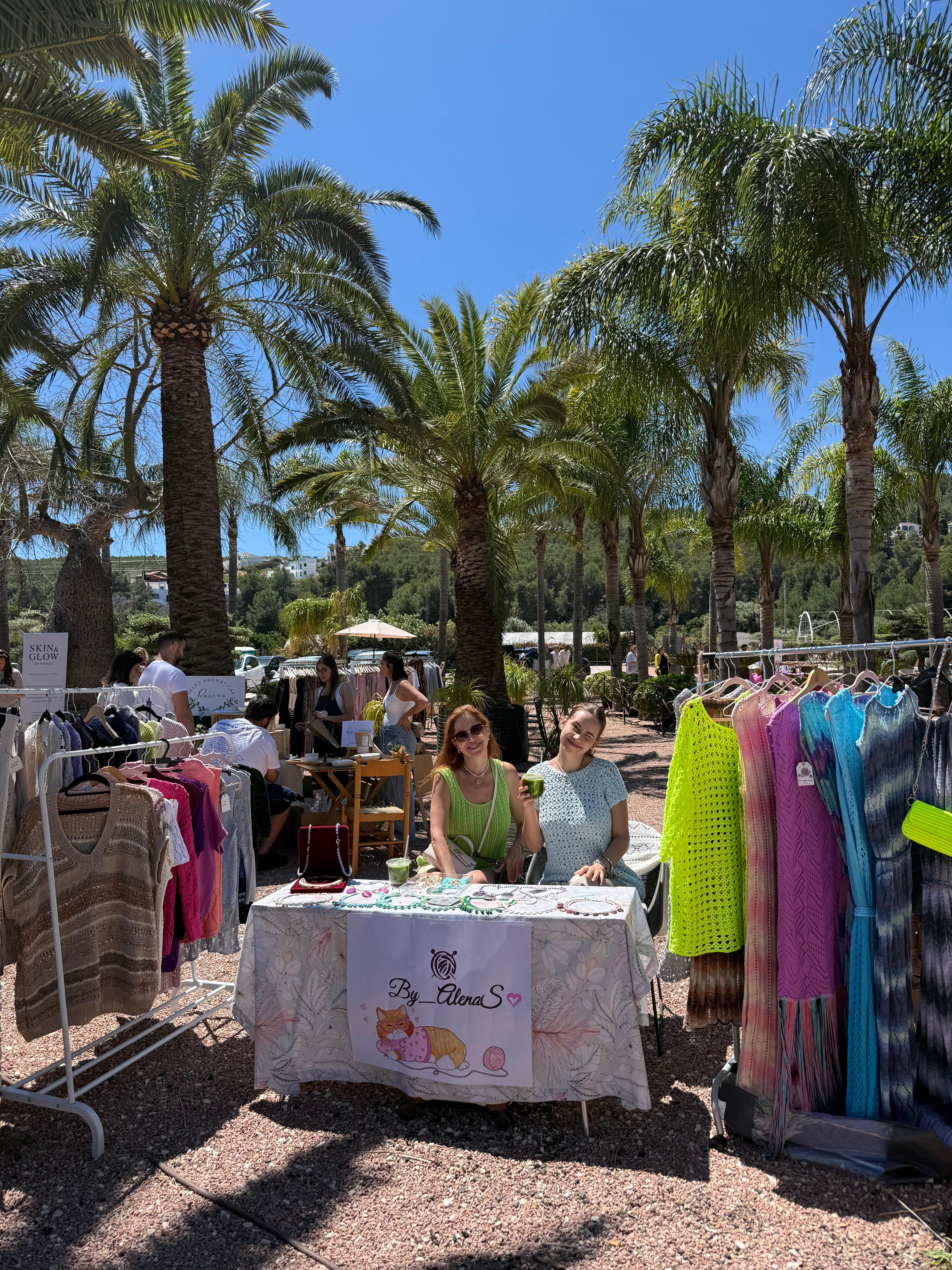 Local stalls beneath palm trees at La Fábrica Spring Fair.